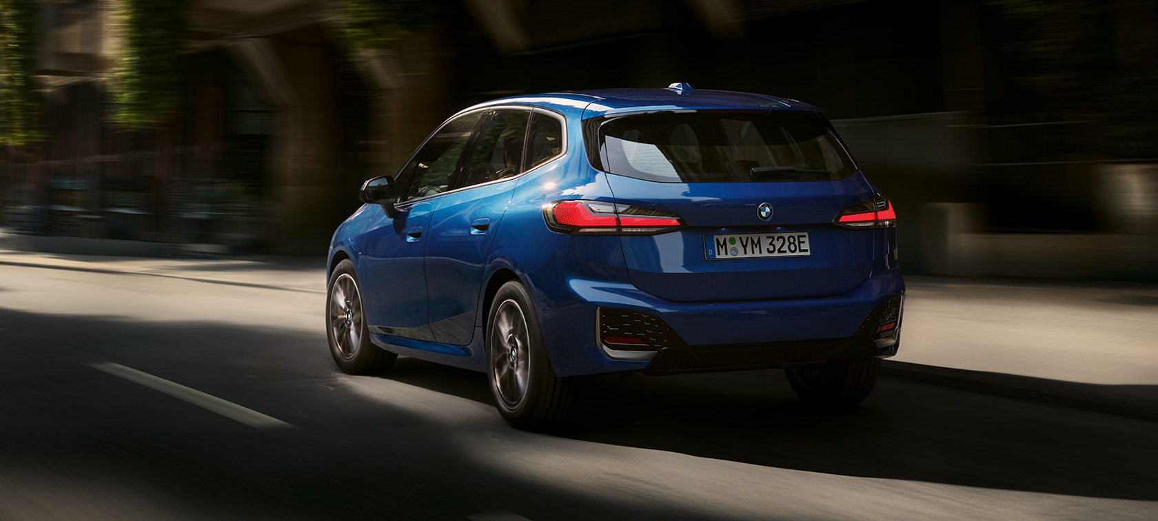 BMW 2 Series Active Tourer 230e plug-in hybrid U06 2021 M Portimao Blue metallic three-quarter rear view driving in the city