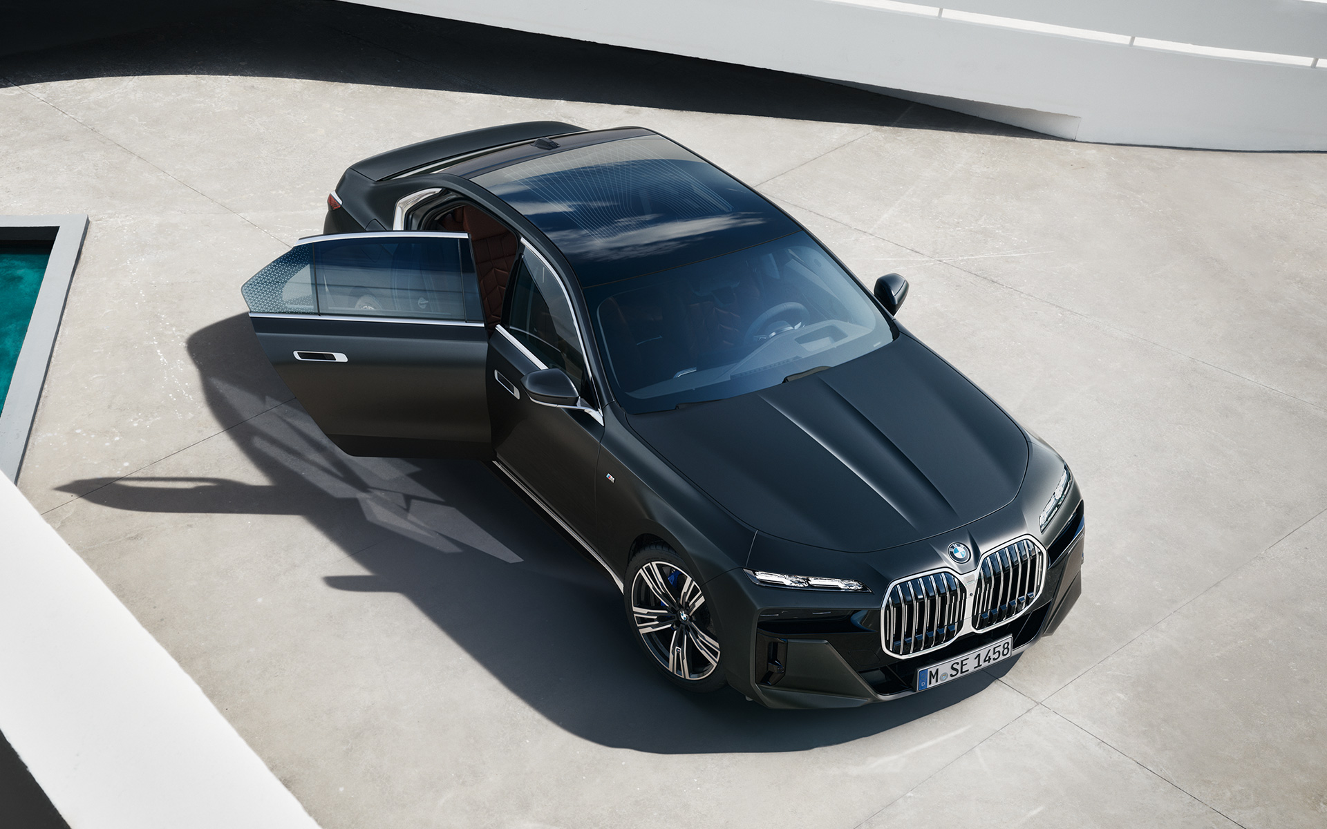 BMW 7 Series Sedan G70 ICE 740i M sports package Frozen Deep Grey metallic bird's eye view with open passenger door